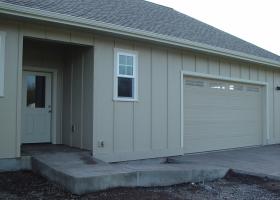 Concrete wheel ramp from driveway to covered house entrance.