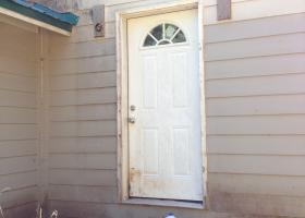 Compromised door and siding. Electrical not installed, no paint, no walk way.